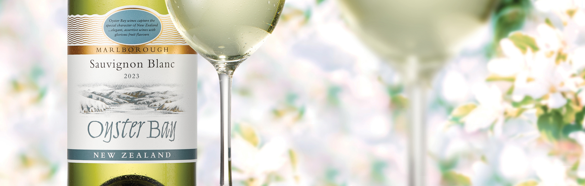 Oyster Bay Sauvignon Blanc bottle with two glasses Desktop INT